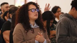 A woman prays with her eyes closed during the service