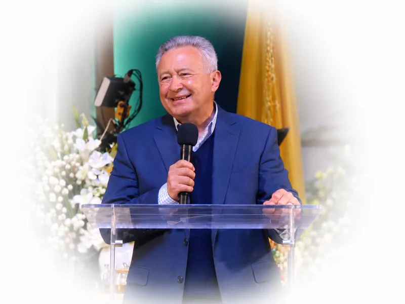 Pastor Juan Radhamés Fernández smiles as he preaches from the pulpit